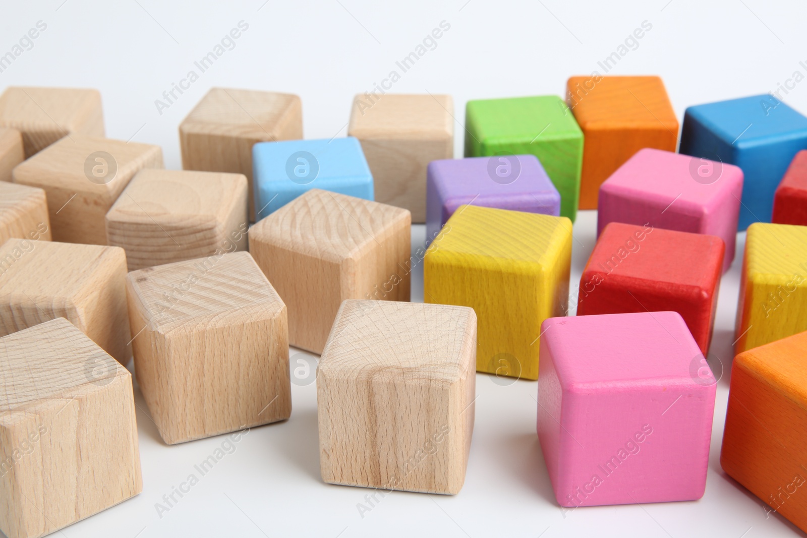 Photo of Many wooden colorful cubes on white background, closeup