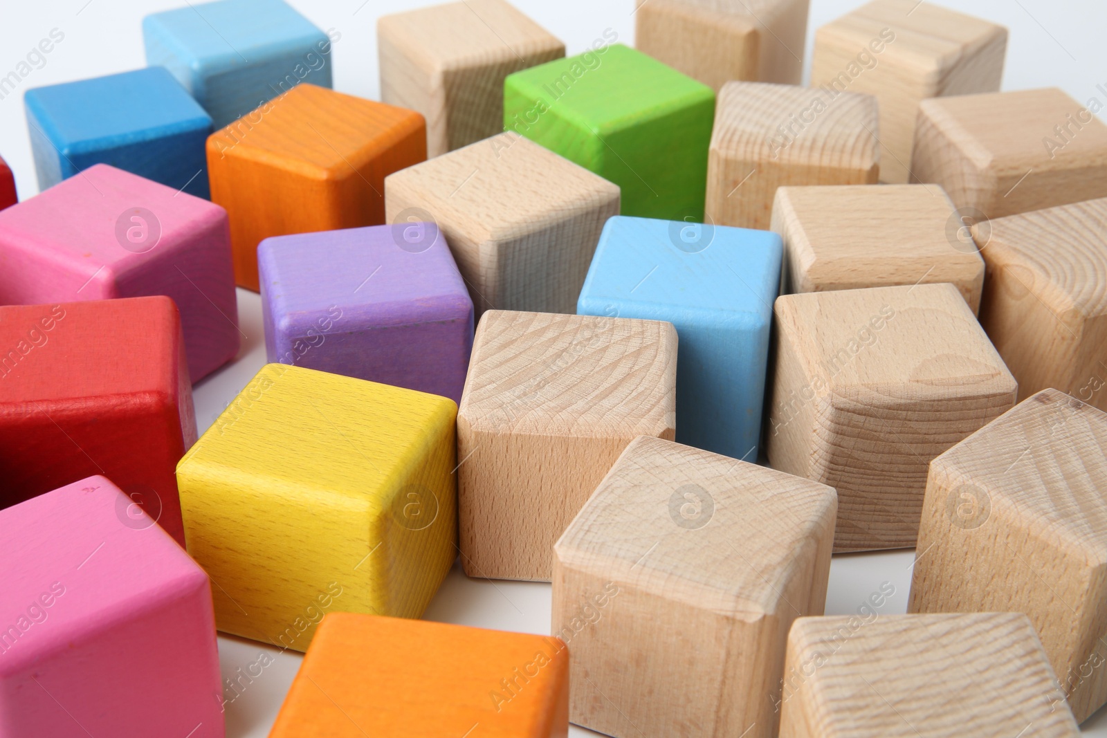 Photo of Many wooden colorful cubes on white background, closeup