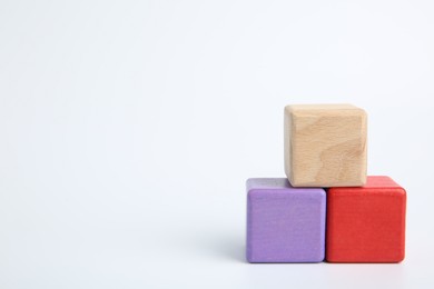 Photo of Pyramid of colorful cubes on white background, space for text