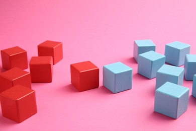 Photo of Many wooden colorful cubes on pink background