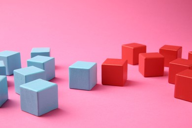 Photo of Many wooden colorful cubes on pink background