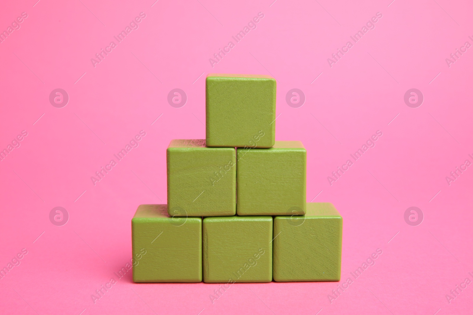 Photo of Pyramid of colorful cubes on pink background