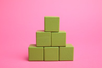 Photo of Pyramid of colorful cubes on pink background