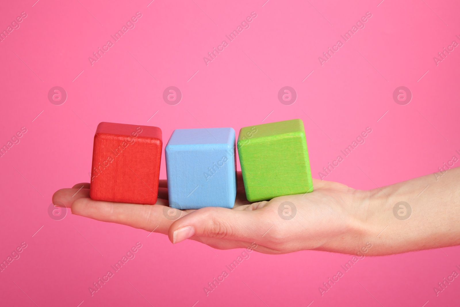 Photo of Woman with colorful cubes on pink background, closeup