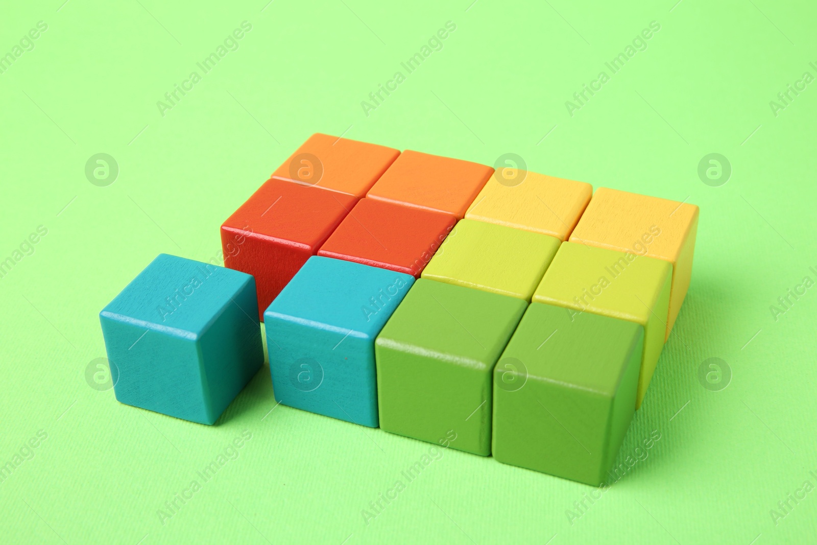 Photo of Many wooden colorful cubes on green background