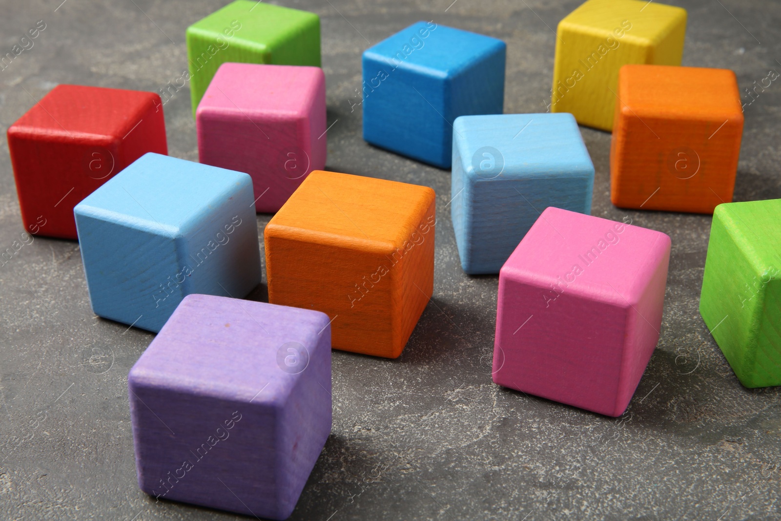 Photo of Many wooden colorful cubes on gray textured background, closeup