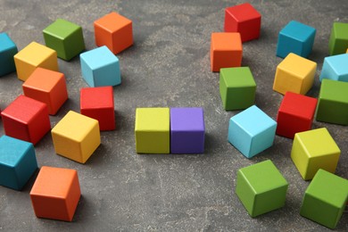 Photo of Many wooden colorful cubes on gray textured background