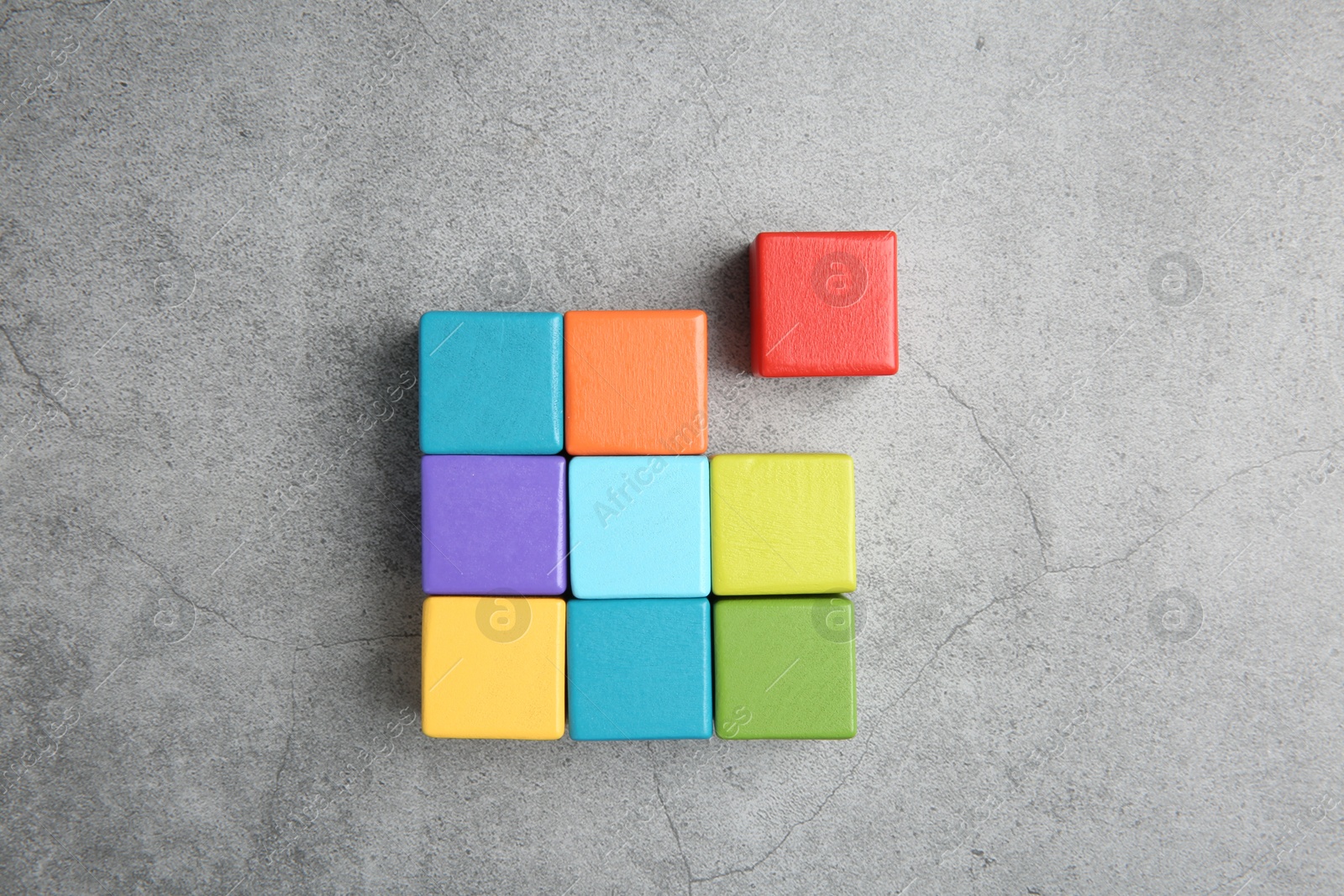 Photo of Many wooden colorful cubes on gray textured background, top view