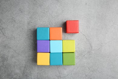 Photo of Many wooden colorful cubes on gray textured background, top view