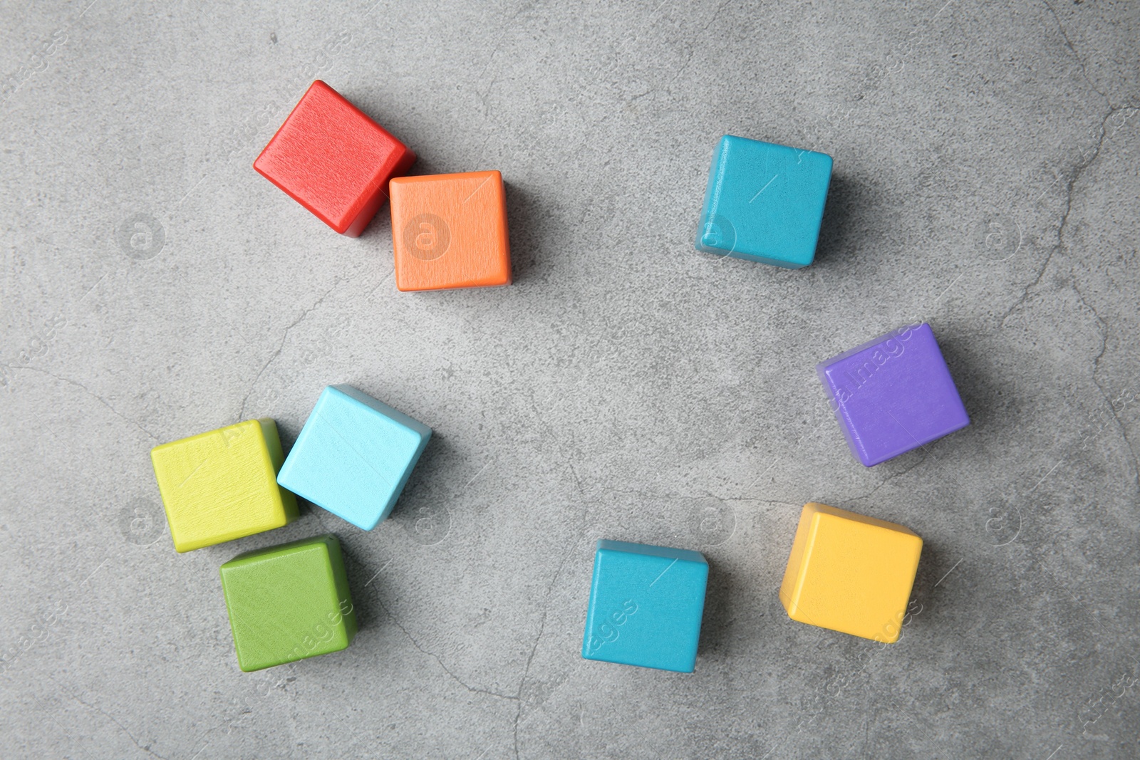 Photo of Many wooden colorful cubes on gray textured background, top view