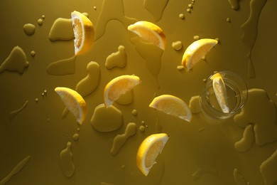 Fresh lemon slices and glass on wet yellow background