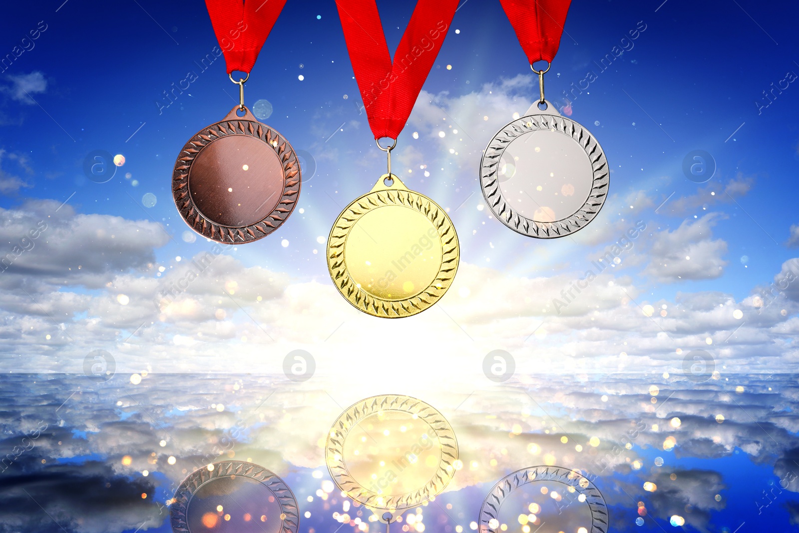 Image of Gold, silver and bronze medals against sky over sea