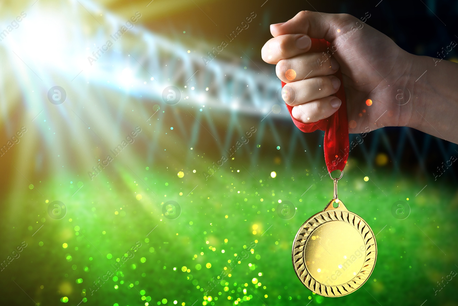 Image of Woman with gold medal at sports field, closeup. Space for text