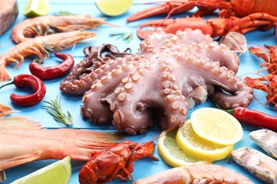 Different sea food on light blue wooden table, closeup