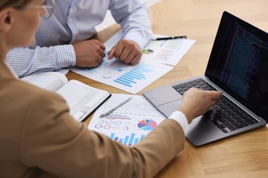 Photo of Banker working with client at wooden table in office, closeup