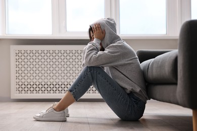 Photo of Loneliness concept. Teenage girl on floor at home