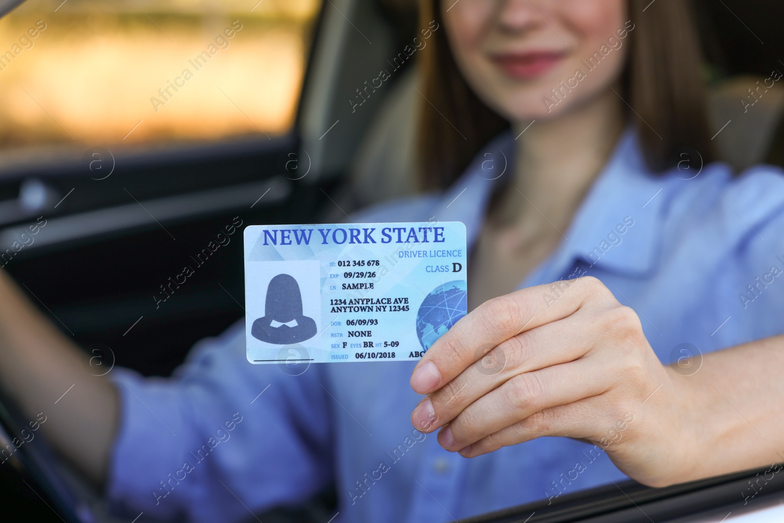 Photo of Driving school. Woman with driving license in car, closeup