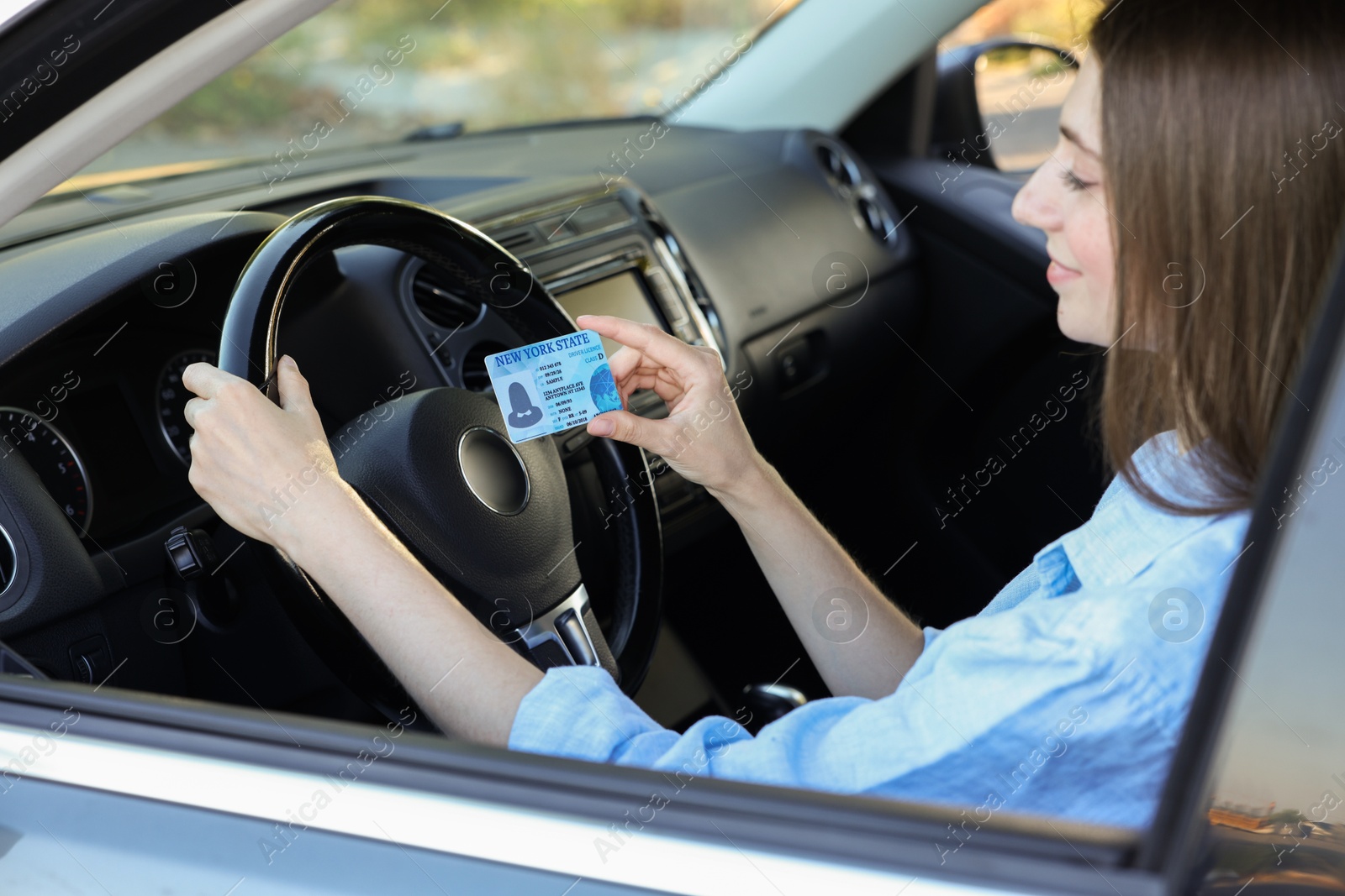 Photo of Driving school. Woman with driving license in car