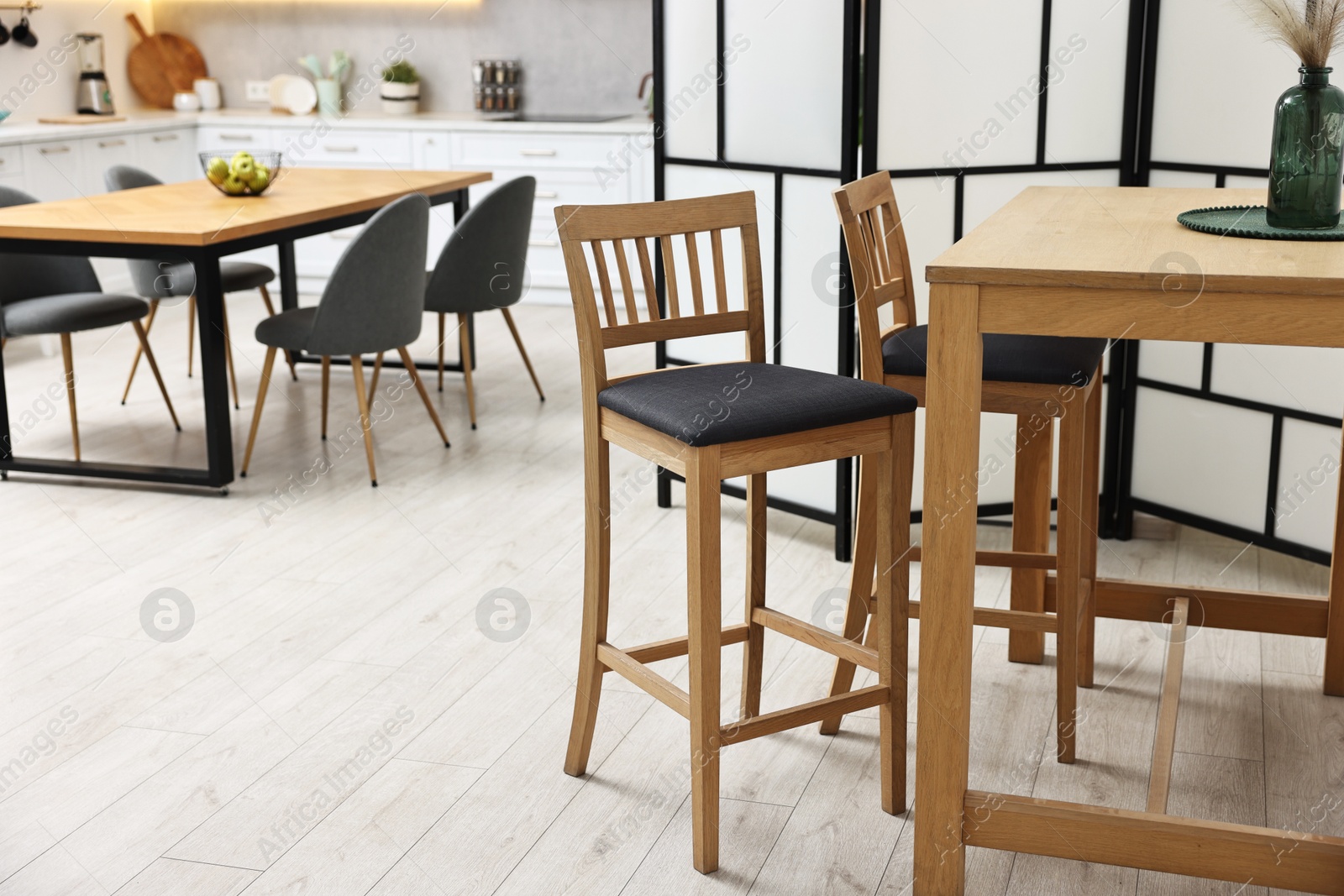 Photo of Stylish stools and table near folding screen indoors