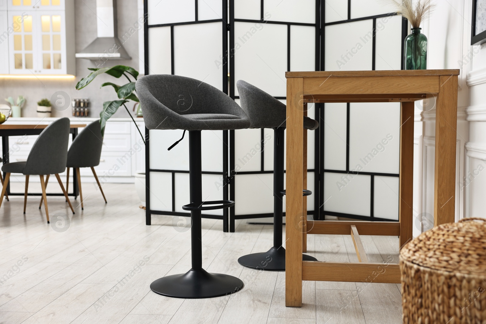 Photo of Bar stools and table near folding screen indoors