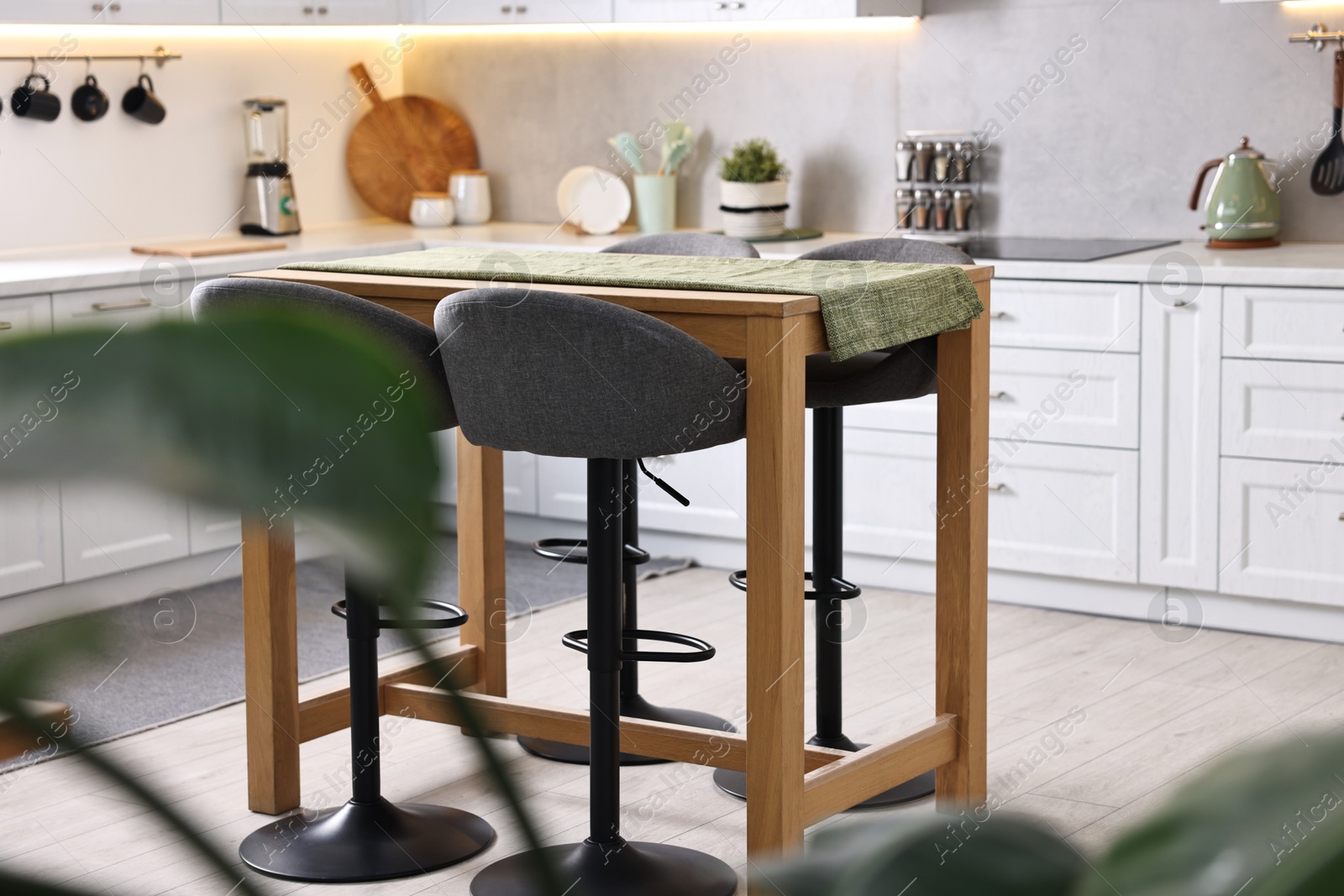 Photo of Bar stools near table in stylish kitchen