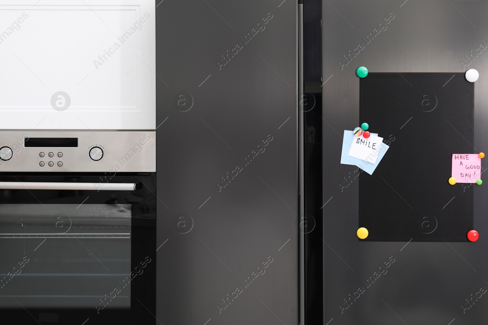 Photo of Magnetic board and notes on refrigerator in kitchen