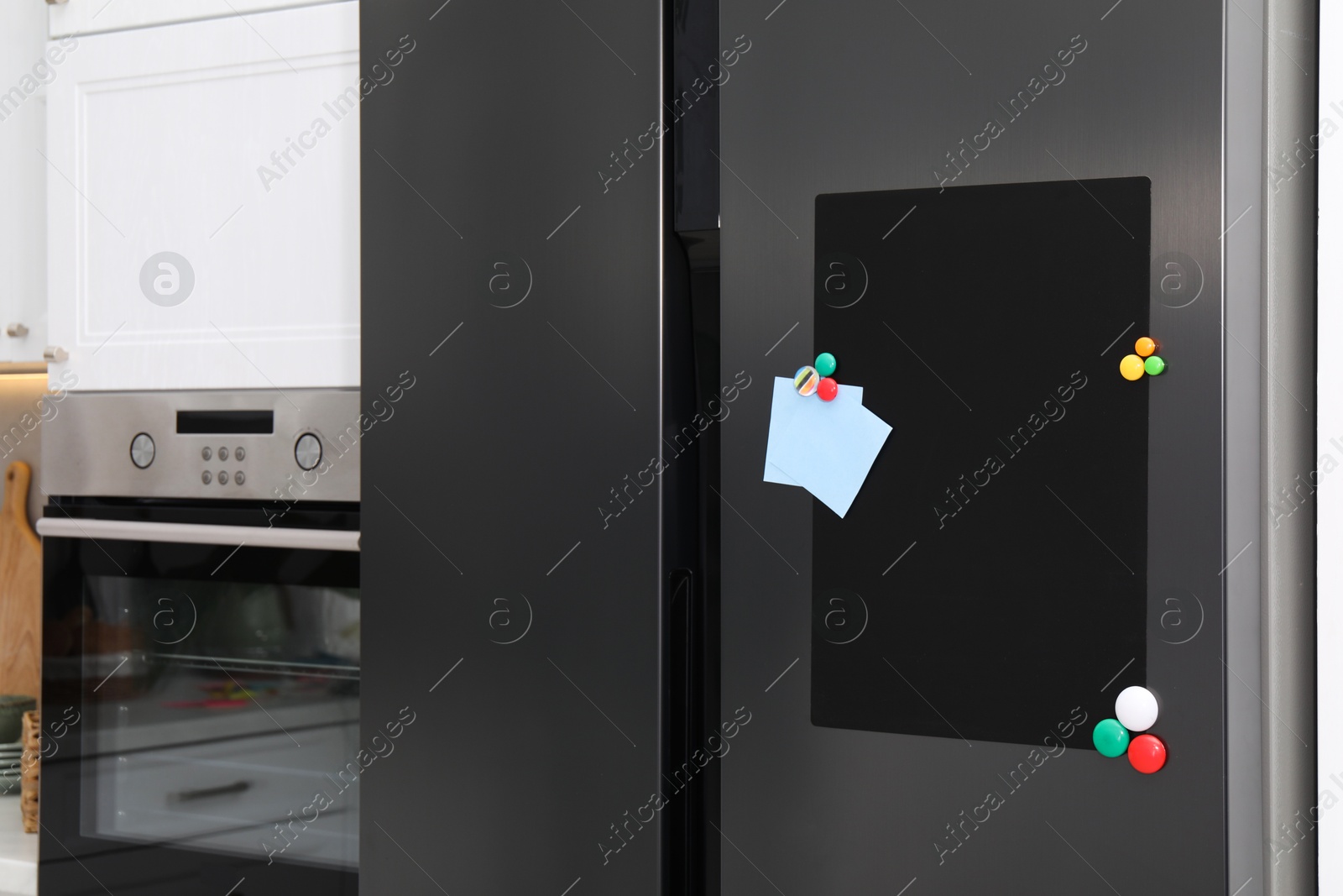 Photo of Magnetic board and notes on refrigerator in kitchen