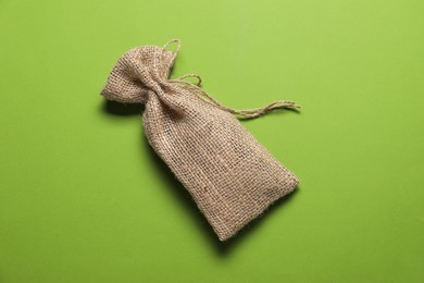 Photo of One burlap sack on green background, top view