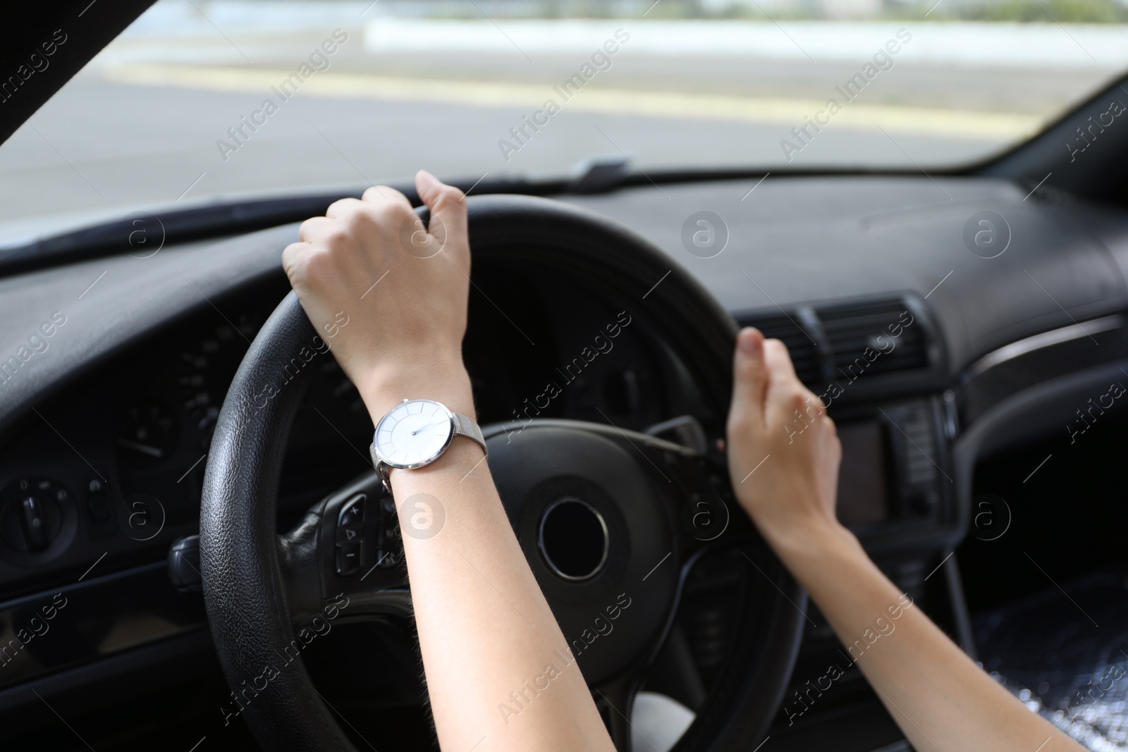 Photo of Woman holding steering wheel while driving car, closeup