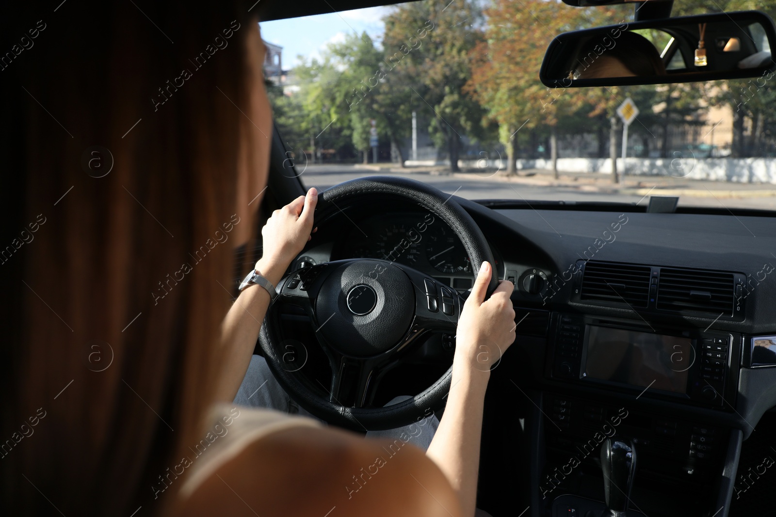 Photo of Woman holding steering wheel while driving car, closeup