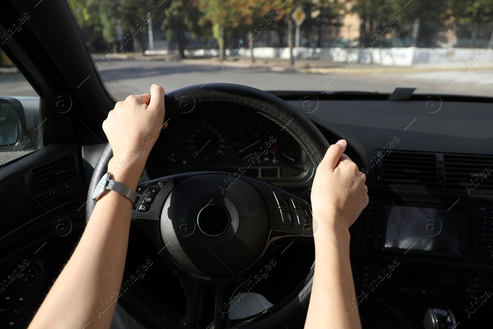 Photo of Woman holding steering wheel while driving car, closeup