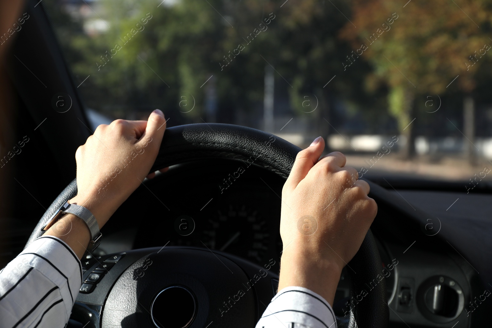 Photo of Woman holding steering wheel while driving car, closeup