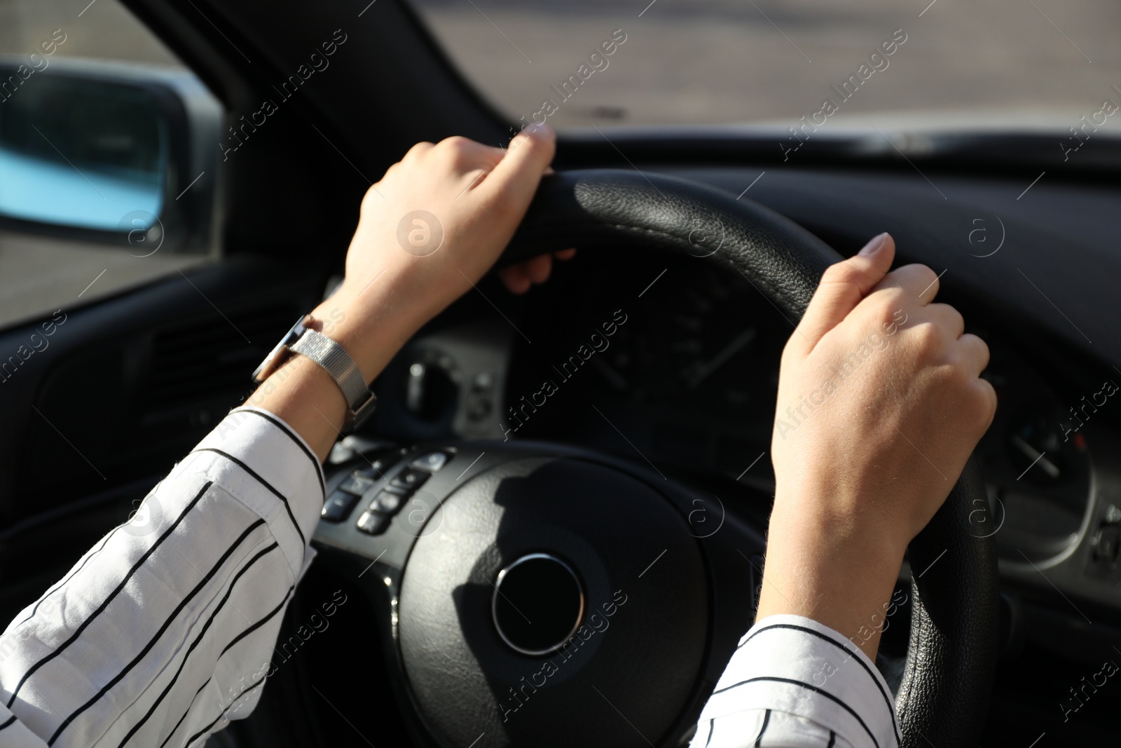 Photo of Woman holding steering wheel while driving car, closeup