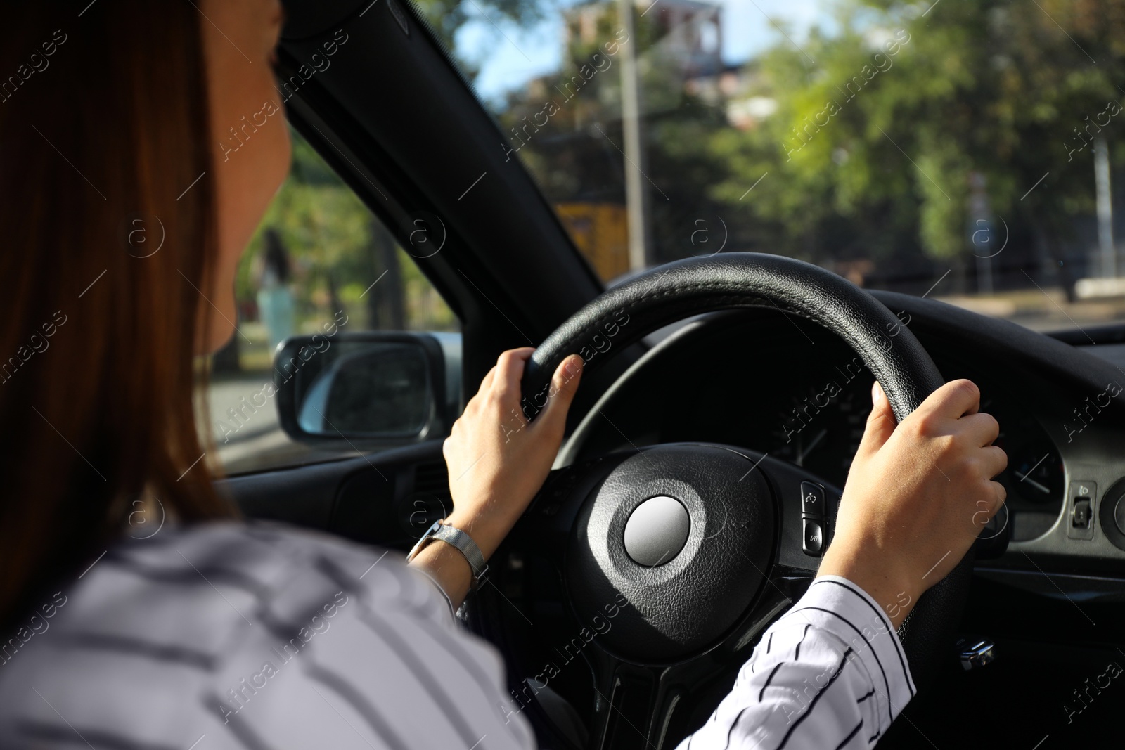 Photo of Woman holding steering wheel while driving car, closeup