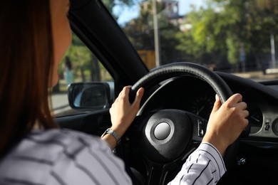 Photo of Woman holding steering wheel while driving car, closeup