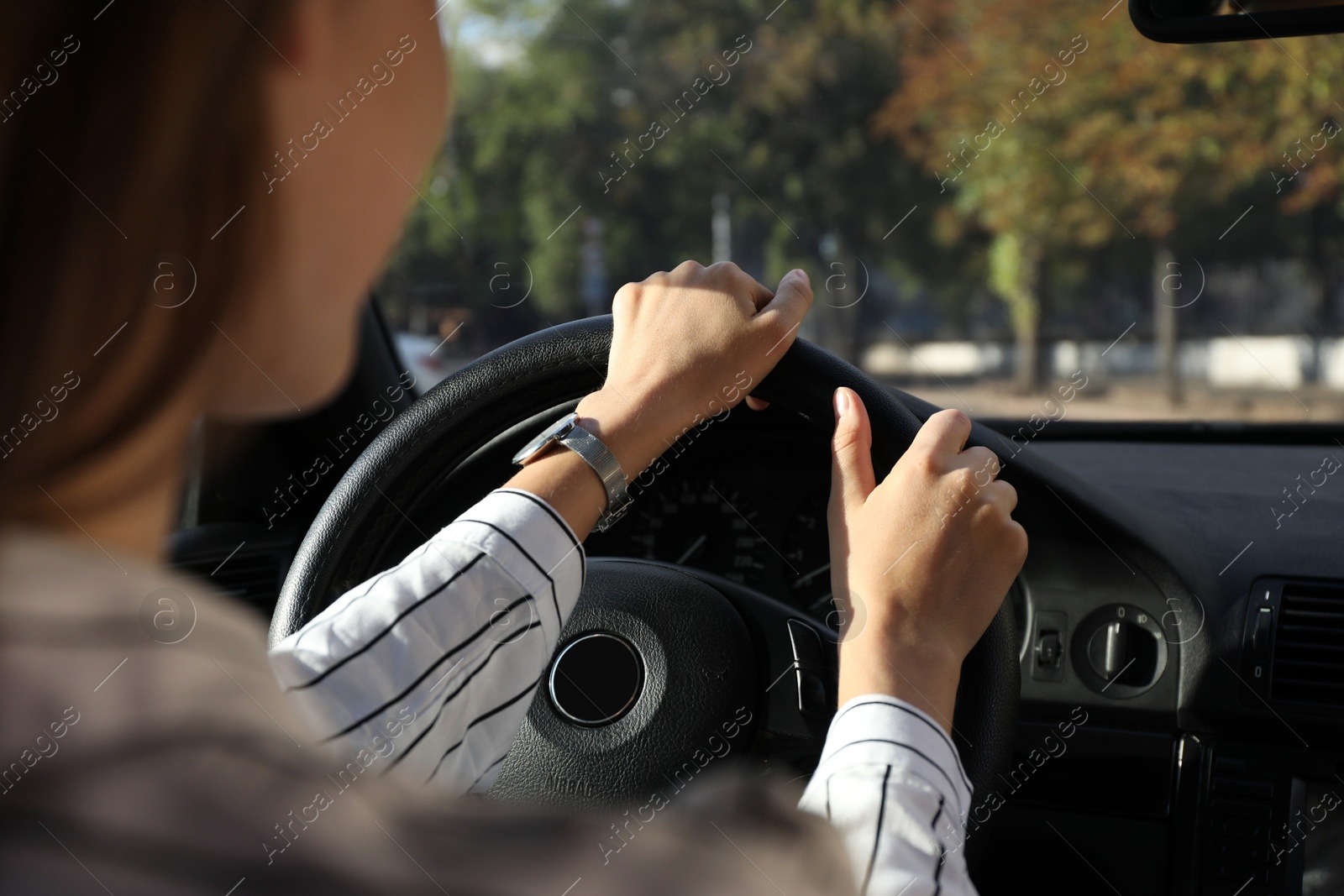 Photo of Woman holding steering wheel while driving car, closeup