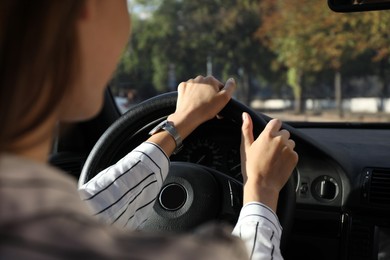 Photo of Woman holding steering wheel while driving car, closeup