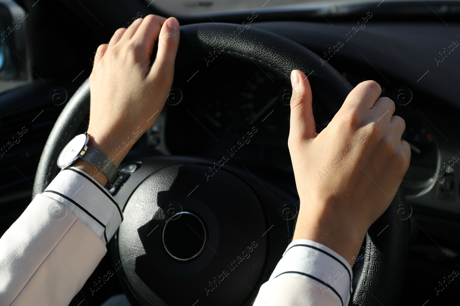 Photo of Woman holding steering wheel while driving car, closeup