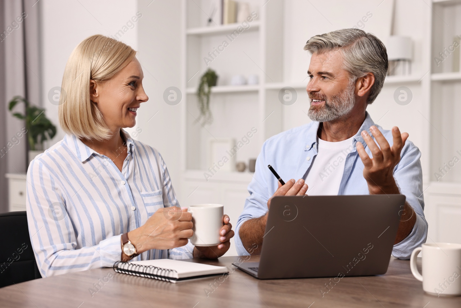 Photo of Pension savings. Couple planning budget at table indoors