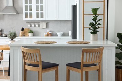 Photo of Stylish kitchen with bar stools. Interior design