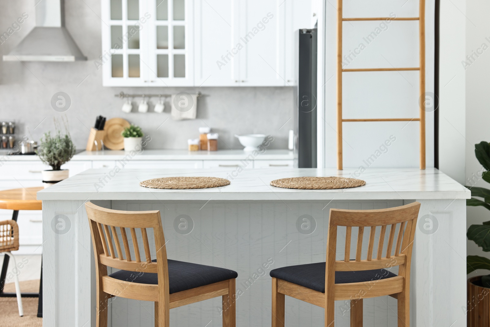 Photo of Stylish kitchen with bar stools. Interior design