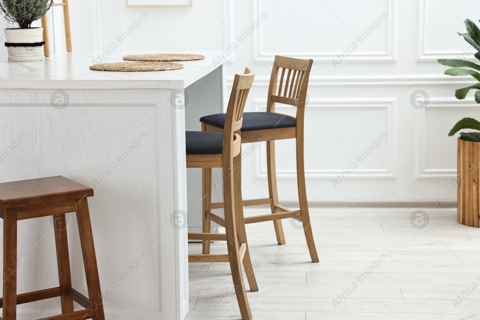 Photo of Stylish dining room with bar stools. Interior design