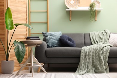 Photo of Living room with stool and sofa. Stylish interior design