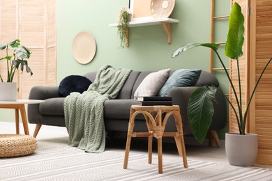 Photo of Living room with stool and sofa. Stylish interior design