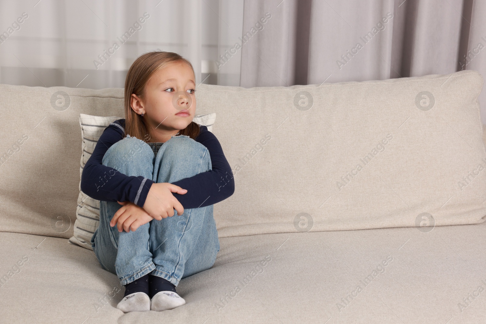 Photo of Autism concept. Lonely little girl on sofa at home