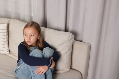 Photo of Autism concept. Lonely little girl on sofa at home