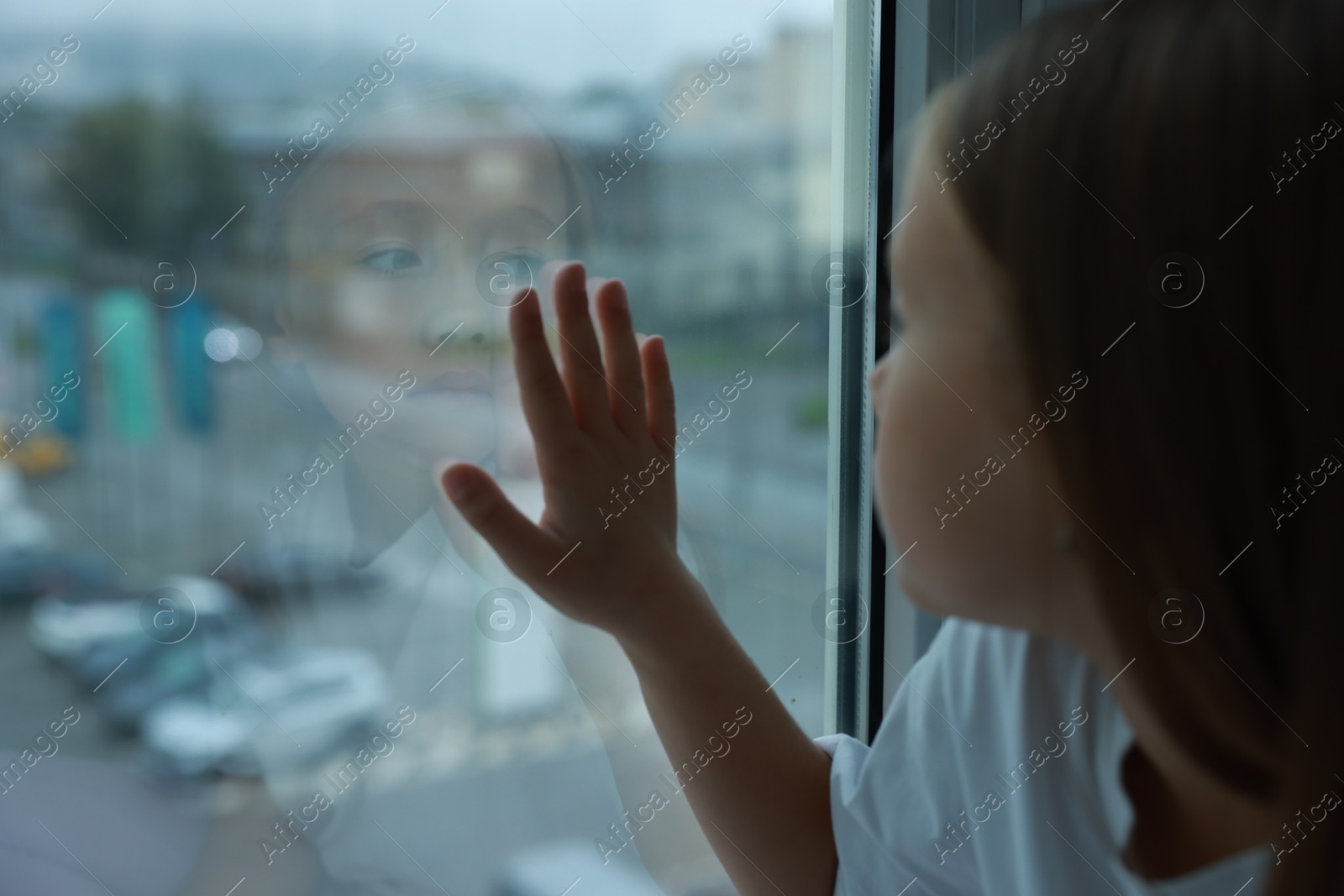 Photo of Autism concept. Lonely little girl near window at home