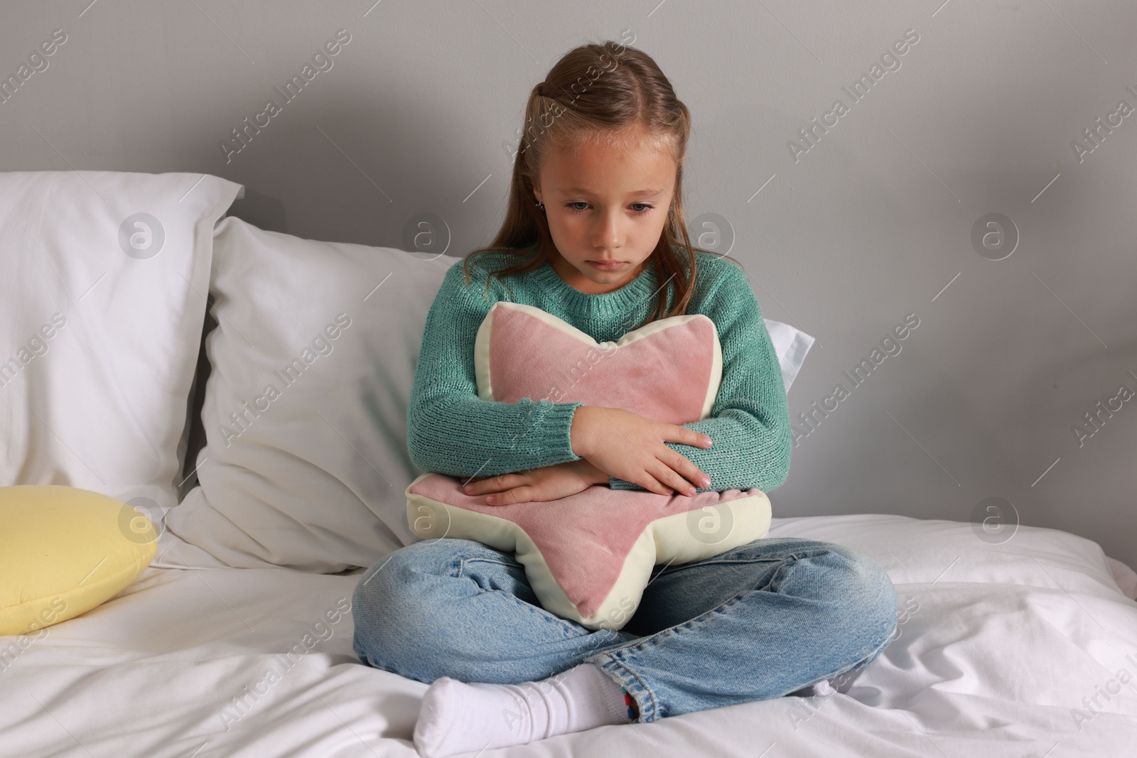 Photo of Autism concept. Lonely little girl with pillow on bed at home