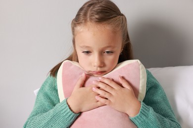 Autism concept. Lonely little girl with pillow at home