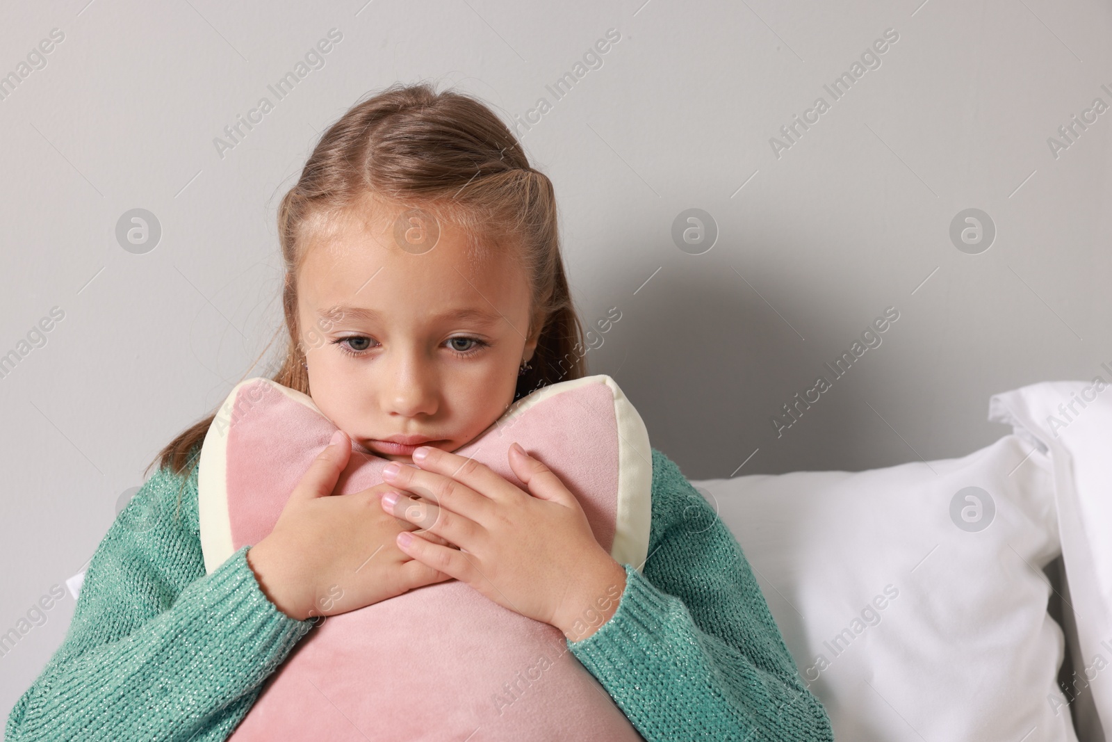 Photo of Autism concept. Lonely little girl with pillow at home